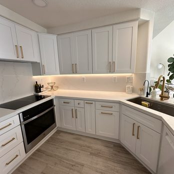 OT Bay Builders - Modern coastal kitchen complete with counter top led lights and built in Hauslane range hood, built in oven and induction cooktop. - General Contractors Near Me - Laguna Niguel, California OT Bay Builders - Modern coastal kitchen complete with counter top led lights and built in Hauslane range hood, built in oven and induction cooktop. - General Contractors Near Me - Laguna Niguel, California