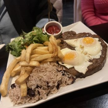Estella Patriot Place - BIFE A CASA Portuguese-style ribeye, over easy egg, house steak sauce, house rice & beans - New American Near Me - Foxborough, Massachusetts Estella Patriot Place - BIFE A CASA Portuguese-style ribeye, over easy egg, house steak sauce, house rice & beans - New American Near Me - Foxborough, Massachusetts