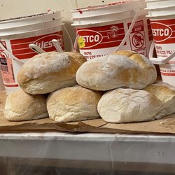 Fresh loaves of bread with barrels of jam spread behind.