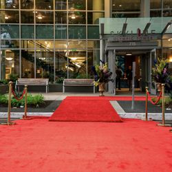 Jashan Event Services - Red carpet rental with gold stanchions and velvet ropes creating a luxury corporate event entrance in downtown Seattle.