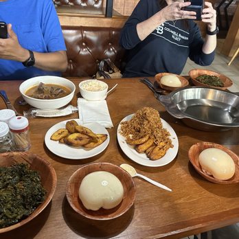 Hunan Cafe - a man taking a picture of a table full of food - African Near Me - Houston, Texas