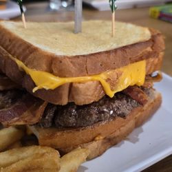 In Plane View - Grilled cheeseburger (grilled cheese on top and bottom with a 1/2 pound burger patty and bacon between them)