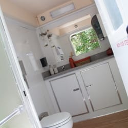 Roomy air conditioned restrooms featuring Vanities, mirrors, flushing toilets, sinks with running water, soap & hand towels.