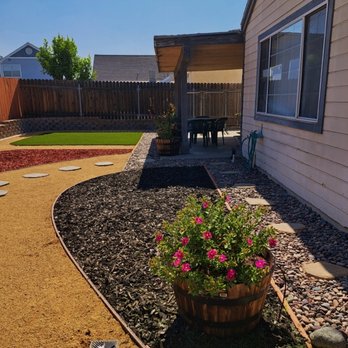 Ruiz Landscape - In foreground: Crimson-Spot Rockrose (blooms during daytime) in wooden barrel planter. To left of plant: one of the 4 installed yard drains. - Landscaping Near Me - Hemet, California