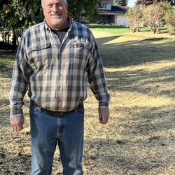 Long's Excavating - Jay Long in front of 22" cut made to drain water away from house.  Jay reseeded and strawed the area.  Grass is coming up already.