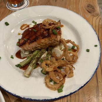 Salt Traders Coastal Cooking - Wood Fired Salmon with asparagus and crispy onion rings - Seafood Near Me - Round Rock, Texas Salt Traders Coastal Cooking - Wood Fired Salmon with asparagus and crispy onion rings - Seafood Near Me - Round Rock, Texas