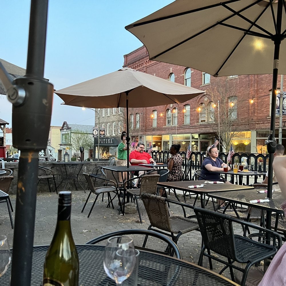 a man sitting at a table with a bottle of wine a man sitting at a table with a bottle of wine