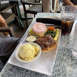 Blackened catch of the day sandwich with side of potato salad.