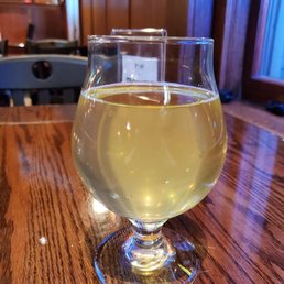 a glass of white wine on a wooden table