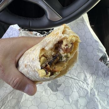 Monti - Breakfast burrito with bacon, potatoes, eggs and cheese and corn. The side sauce completes it for sure! - Breakfast & Brunch Near Me - Holladay, Utah Monti - Breakfast burrito with bacon, potatoes, eggs and cheese and corn. The side sauce completes it for sure! - Breakfast & Brunch Near Me - Holladay, Utah