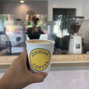 Jedidiah Coffee - a hand holding a cup of coffee - Coffee & Tea Near Me - Laguna Beach, California