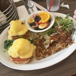 Veggie eggs Benedict with hash browns, arugula, and fruit.