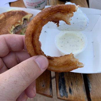 Nathans - a hand holding a half eaten donut - Hot Dogs Near Me - Westlake, Ohio Nathans - a hand holding a half eaten donut - Hot Dogs Near Me - Westlake, Ohio