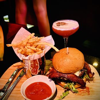 Riviera 31 - Wagyu Burger with crispy bacon, heirloom tomato, truffle Gouda, arugula, huckleberry spread, and pickles with truffle fries - Bars Near Me - Los Angeles, California Riviera 31 - Wagyu Burger with crispy bacon, heirloom tomato, truffle Gouda, arugula, huckleberry spread, and pickles with truffle fries - Bars Near Me - Los Angeles, California
