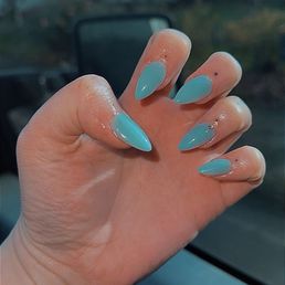 Glow in the dark blue nails with iredescent diamond on ring finger. Glow in the dark blue nails with iredescent diamond on ring finger.