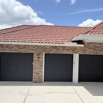 Just In Time Garage Door - Three-door replacement on a tile-roof home -- dark doors against brick. - Garage Door Services Near Me - Mount Dora, Florida Just In Time Garage Door - Three-door replacement on a tile-roof home -- dark doors against brick. - Garage Door Services Near Me - Mount Dora, Florida