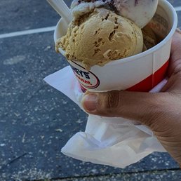a hand holding a cup of ice cream a hand holding a cup of ice cream