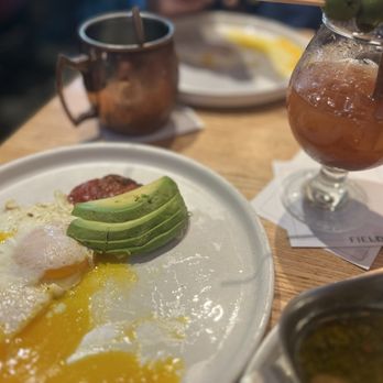 Fielding's Wood Grill - Eggs over easy, avocado, sun dried tomato, Bloody Mary, chimichurri steak, and a Moscal Mule. - New American Near Me - Shenandoah, Texas