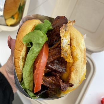 Bro’kin Yolk Express - a hand holding a hamburger - Breakfast & Brunch Near Me - Calgary, Alberta