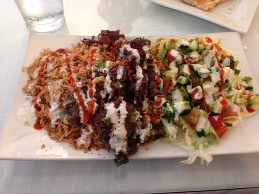 Photo of Zara Afghan Cuisine - Sacramento, CA, US. $7 lunch. Beef kabob over rice and salad, topped with sriracha and what I think is some kind of mint sauce. It's wonderful.