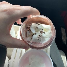  a hand holding a cup of ice cream