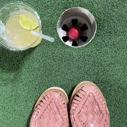 a woman's feet with a pink slipper and a glass of lemonade a woman's feet with a pink slipper and a glass of lemonade