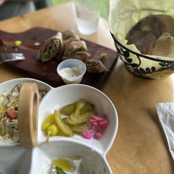 Toot Beirut - a wooden table with bowls of food and utensils - Middle Eastern Near Me - Rogers, Arkansas Toot Beirut - a wooden table with bowls of food and utensils - Middle Eastern Near Me - Rogers, Arkansas