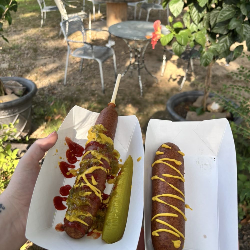 Medium Corn Dog with mustard, ketchup, and relish with a side pickle and a Hot Mama Corn Dog Medium Corn Dog with mustard, ketchup, and relish with a side pickle and a Hot Mama Corn Dog