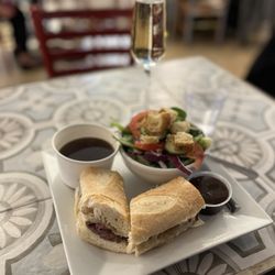Amélie's French Bakery & Café - French dip, side salad , and Prosecco