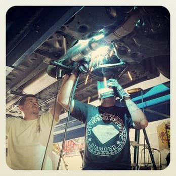 Spanky's Muffler - Spanky holds the piece while his son welds the new rear converter and pipe into place. - Auto Repair Near Me - Phoenix, Arizona