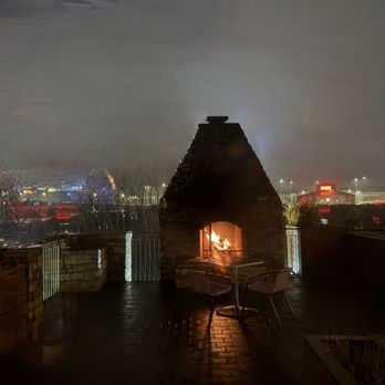 The Saddle Room - An outdoor patio fireplace, lit up on this foggy evening. - Steakhouses Near Me - Hoffman Estates, Illinois
