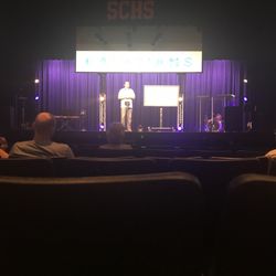 A Family Church - Pastor speaking on the high school theater stage.