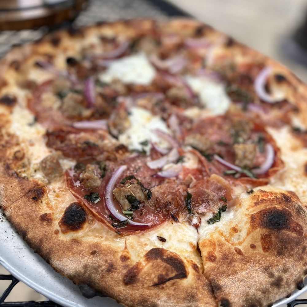 V Pizza Brier Creek + Flask - a pizza on a plate on a table - Chicken Wings Near Me - Raleigh, North Carolina V Pizza Brier Creek + Flask - a pizza on a plate on a table - Chicken Wings Near Me - Raleigh, North Carolina