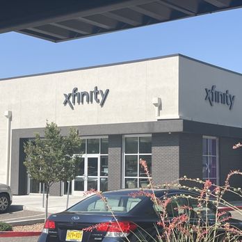 Xfinity Store by Comcast - The store - Xfinity Store building with signage, parked cars, and landscaping including a small tree and ornamental grass. - Internet Service Providers Near Me - Albuquerque, New Mexico