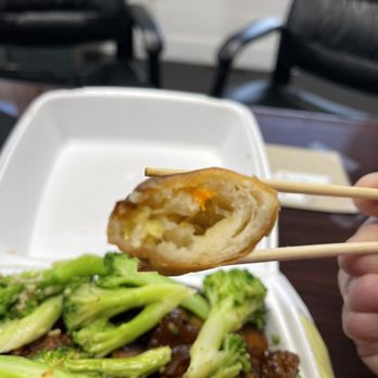 Ding Ho Restaurant - a person holding chopsticks over a dish of broccoli - Chinese Near Me - Boston, Massachusetts Ding Ho Restaurant - a person holding chopsticks over a dish of broccoli - Chinese Near Me - Boston, Massachusetts