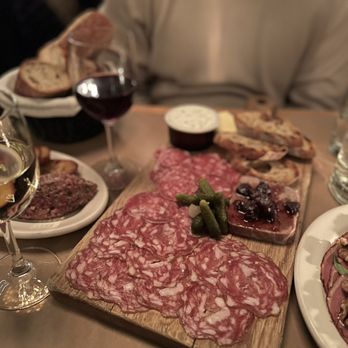 Le Caviste - a man sitting at a table with food and wine - Wine Bars Near Me - Seattle, Washington Le Caviste - a man sitting at a table with food and wine - Wine Bars Near Me - Seattle, Washington