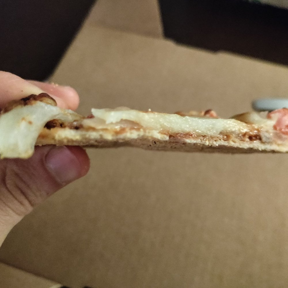 Bluestone - a hand holding a piece of pizza - American Near Me - Evanston, Illinois Bluestone - a hand holding a piece of pizza - American Near Me - Evanston, Illinois