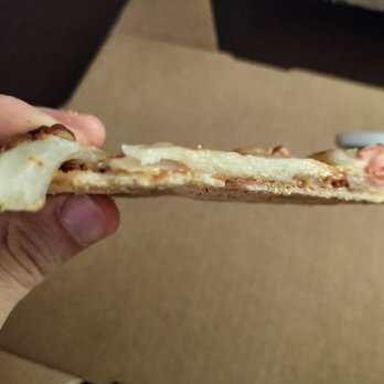 Bluestone - a hand holding a piece of pizza - American Near Me - Evanston, Illinois