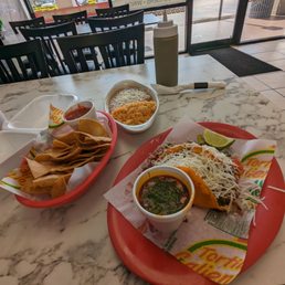 Birria tacos with consomme. Some chips with salsa, refried beans and rice