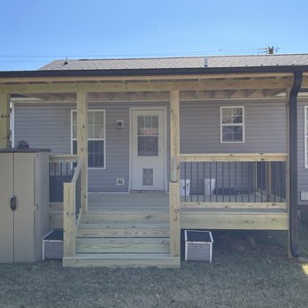 Decked Out Contracting - a porch with steps leading to the front door - Decks & Railing Near Me
