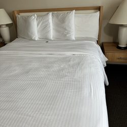 Aladdin Inn and Suites - Bed with tag showing. Linens seem clean but very worn.