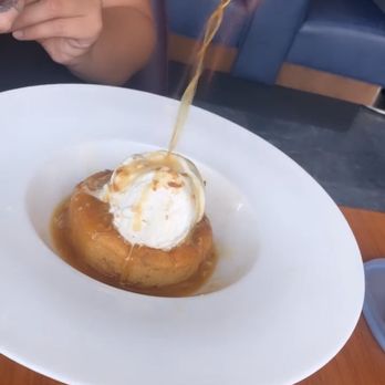 Aurora At The Celeste - Pineapple bread pudding while the flaming pineapple rum sauce being poured on. - American Near Me - Orlando, Florida Aurora At The Celeste - Pineapple bread pudding while the flaming pineapple rum sauce being poured on. - American Near Me - Orlando, Florida