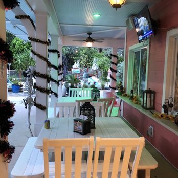 Putt'n Around - a porch with a table and chairs - Mini Golf Near Me - Delray Beach, Florida