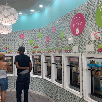 sweetFrog Premium Frozen Yogurt - a man and a woman looking at the machines - Ice Cream & Frozen Yogurt Near Me - Silver Spring, Maryland