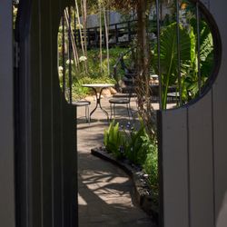 The Rochers at the Ranch House - A peek through the garden gate offers a first glimpse of the lush, hidden world that awaits just beyond.
