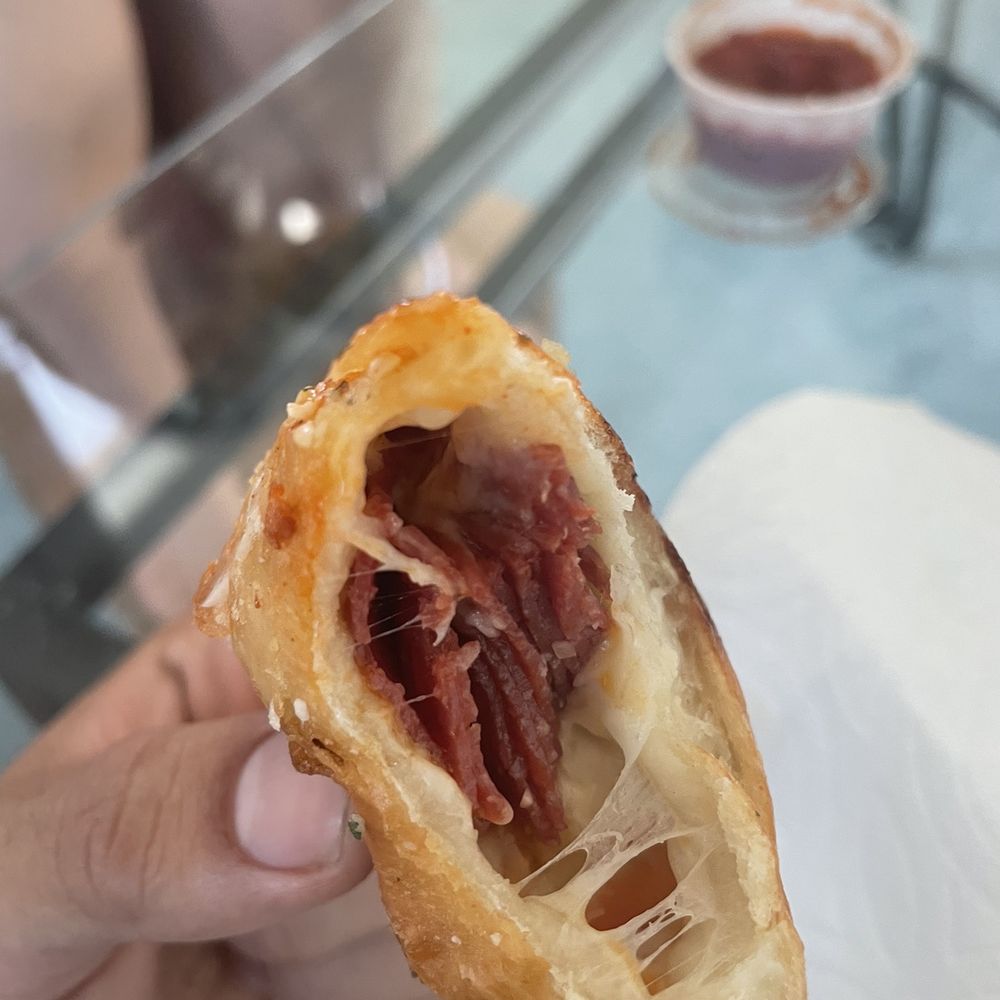 UPC Pizza - a person holding a half eaten pastry - Pizza Near Me - Riverside, California UPC Pizza - a person holding a half eaten pastry - Pizza Near Me - Riverside, California
