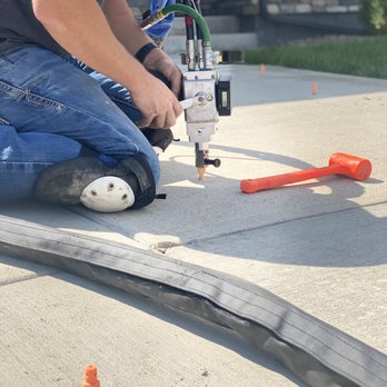 Elevation Lifting & Leveling - a man using a drill - Masonry/Concrete Near Me Elevation Lifting & Leveling - a man using a drill - Masonry/Concrete Near Me