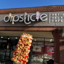 Dipsticle - Strawberry Cheescake with strawberry syrup, pistachios, and waffle cone toppings!