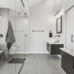 DreamMaker Bath & Kitchen - Modern master bath remodel at Lake Springfield. Tiled shower, built in bench, linear drain, doorless entry. Floating vanities, vessel sinks.