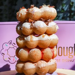 a stack of doughnuts on a wooden plate a stack of doughnuts on a wooden plate